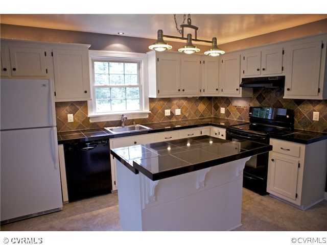 9103 Peaks Road Ashland, VA 23005 - Photo 4 of 12 a kitchen with granite countertop a sink dishwasher a refrigerator a stove and white cabinets with wooden floor