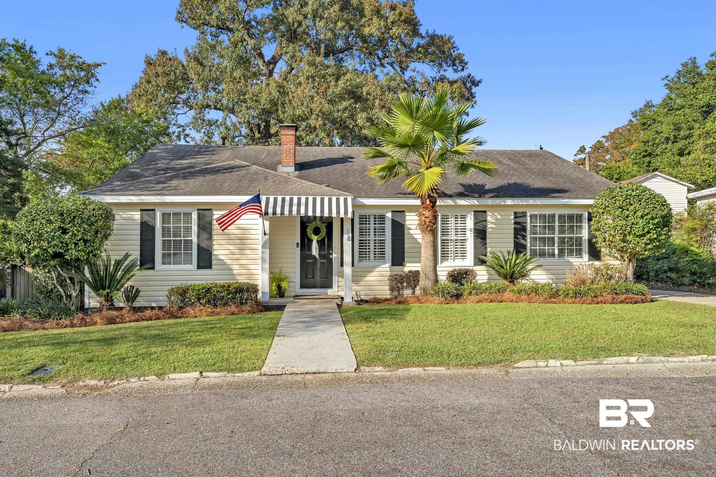 18 York Place Mobile, AL 36608 - Photo 1 of 27 View of front of house with a shingled roof, a front lawn, and a chimney