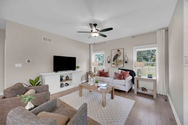 a living room with furniture a rug and a flat screen tv