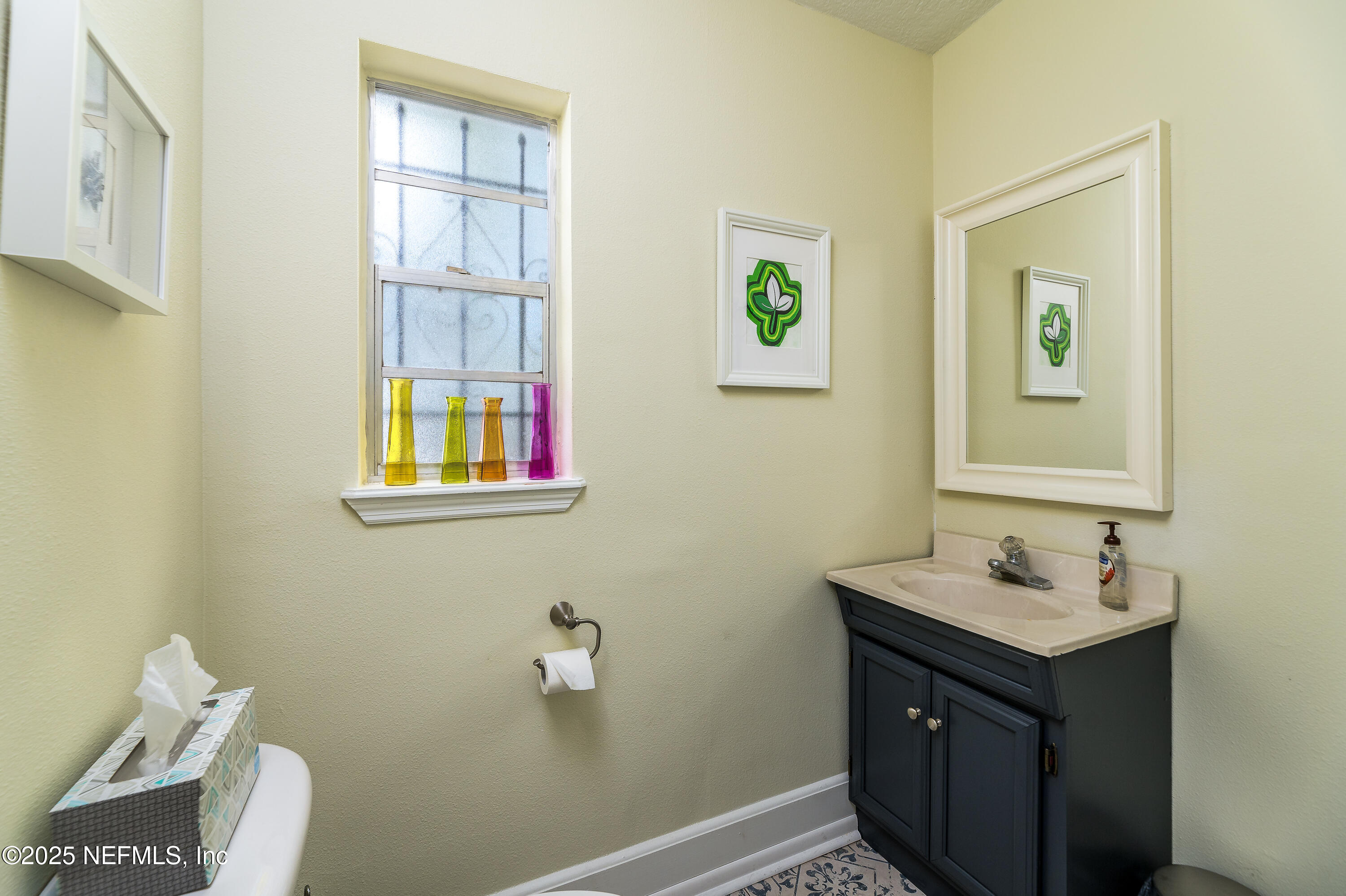 7419 Merrill Road Jacksonville, FL 32277 - Photo 12 of 12 a bathroom with a sink and a mirror