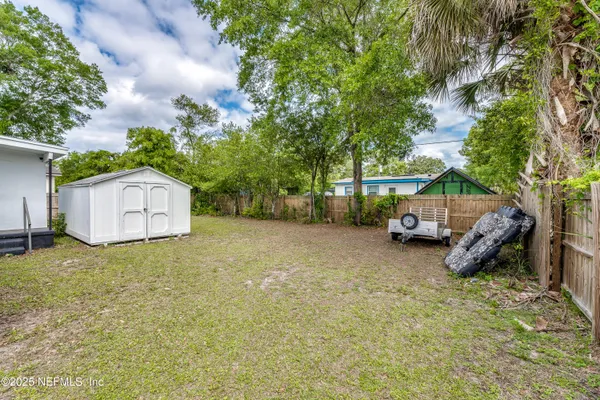 a view of a house with backyard and a tree