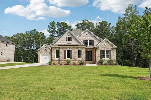 a view of a house with a yard potted plants and large tree