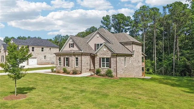 a view of house with a big yard and potted plants in front of it