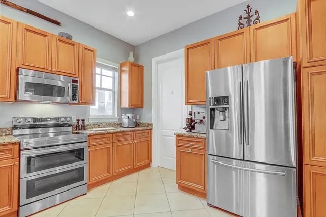 a kitchen with a sink a counter top space and living room view