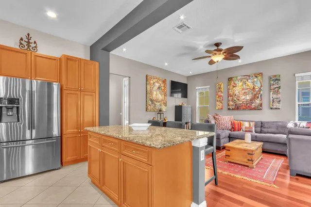 a kitchen with stainless steel appliances a stove a sink a counter space and chairs