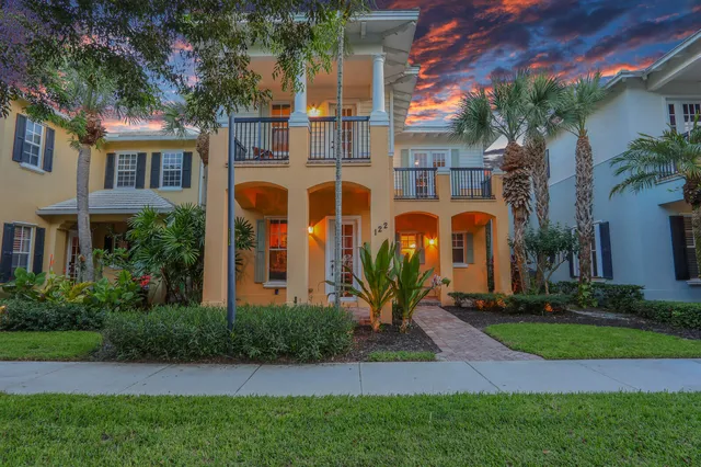 a front view of a multi story residential apartment building with yard and green space