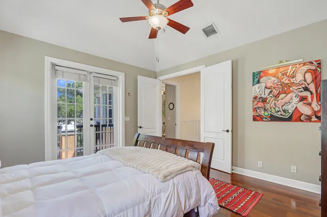 a bedroom with a bed dresser and a large window