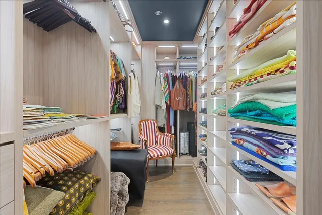 a view of walk in closet with clothes and shoes