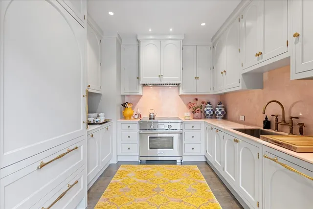 a kitchen with stainless steel appliances granite countertop a stove and white cabinets