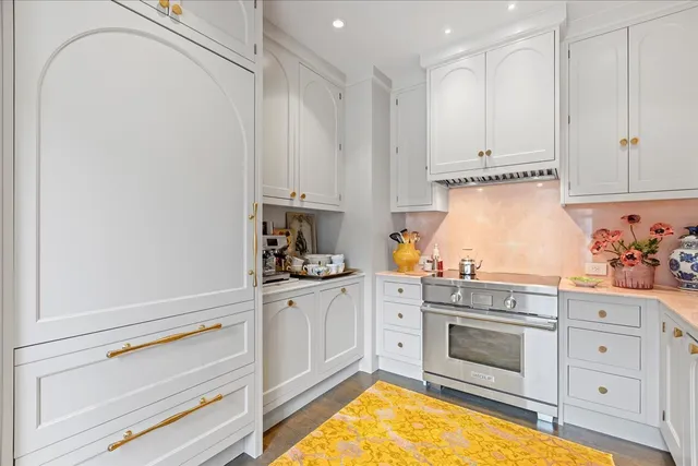 a kitchen with granite countertop white cabinets and white appliances