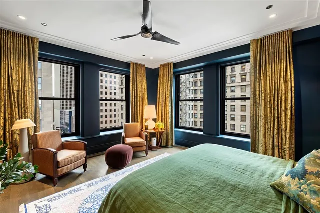 a bedroom with a bed couch and a large window