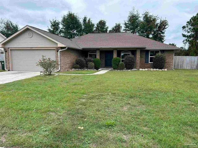 a front view of a house with a yard and trees