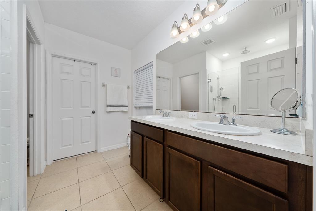 669 Jupiter Beach Road Groveland, FL 34736 - Photo 12 of 41 a bathroom with a double vanity sink and a mirror