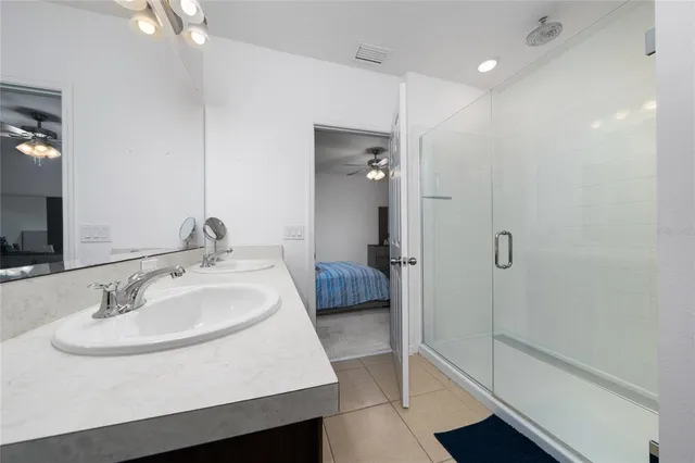 a en suite bathroom with a sink a mirror and a shower