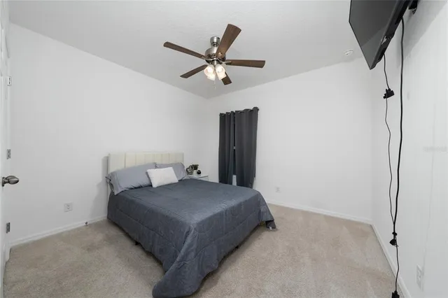 a bedroom with a bed and ceiling fan