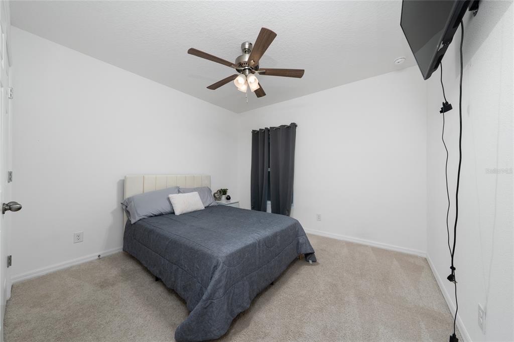 669 Jupiter Beach Road Groveland, FL 34736 - Photo 14 of 41 a bedroom with a bed and ceiling fan