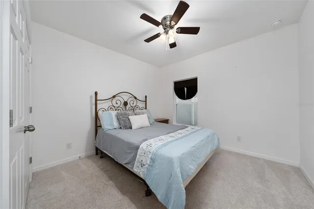 a bedroom with a bed and a ceiling fan
