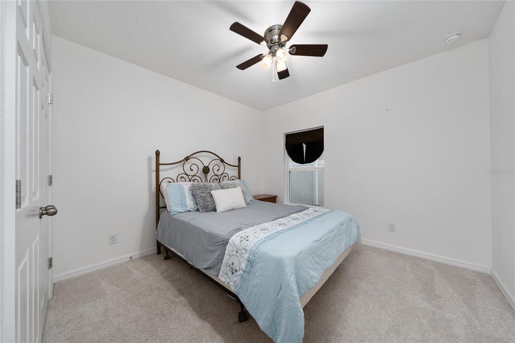 669 Jupiter Beach Road Groveland, FL 34736 - Photo 16 of 41 a bedroom with a bed and a ceiling fan