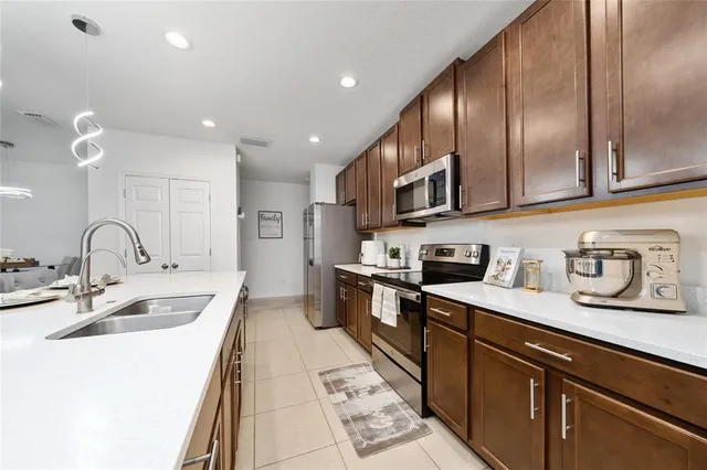 a kitchen with stainless steel appliances granite countertop a sink stove and cabinets