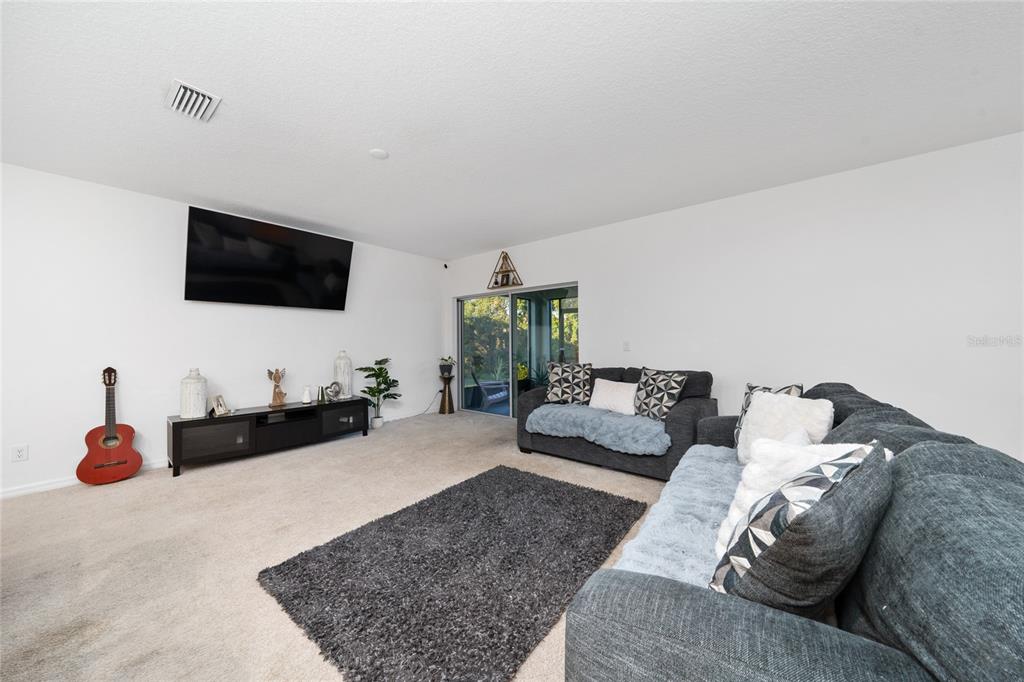 669 Jupiter Beach Road Groveland, FL 34736 - Photo 6 of 41 a living room with furniture and a flat screen tv