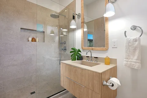 a bathroom with a sink a mirror a vanity and shower
