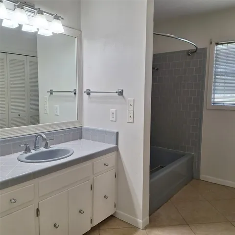 a bathroom with a tub sink and mirror