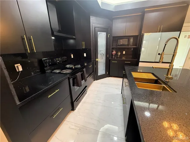 a kitchen with stainless steel appliances granite countertop a refrigerator and a stove