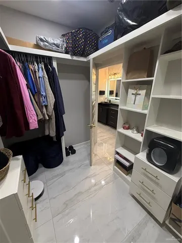 a view of walk in closet with clothes and shoes