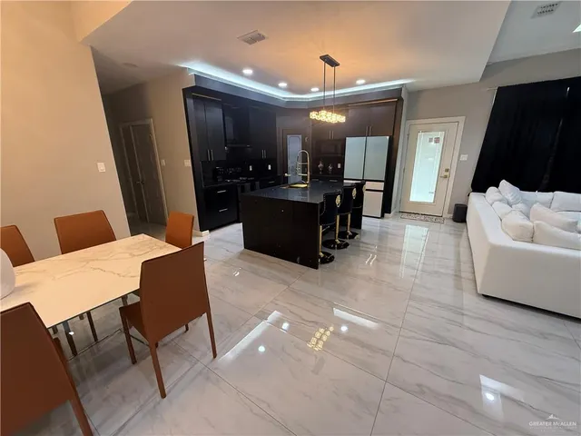 a large living room with stainless steel appliances furniture a rug and a view