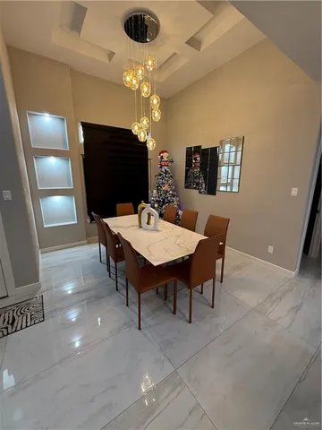 a view of a dining room with furniture and a chandelier