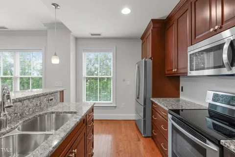 a kitchen with stainless steel appliances granite countertop a sink stove and cabinets