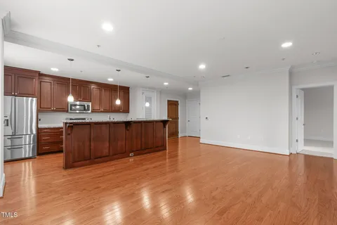 a kitchen with a sink and a stove with wooden floor