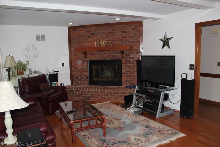 4804 Sweetbriar Road Greensboro, NC 27455 - Photo 7 of 14 Large family room with fireplace. Sliding doors off den to porch. Beautiful hardwood floors