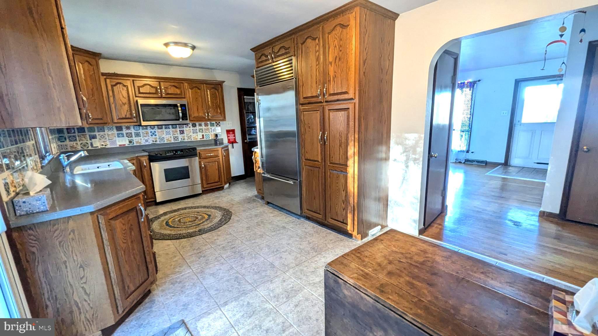 429 Simpson Street Bellefonte, PA 16823 - Photo 12 of 27 a kitchen with stainless steel appliances granite countertop a refrigerator a stove and a sink with wooden floor