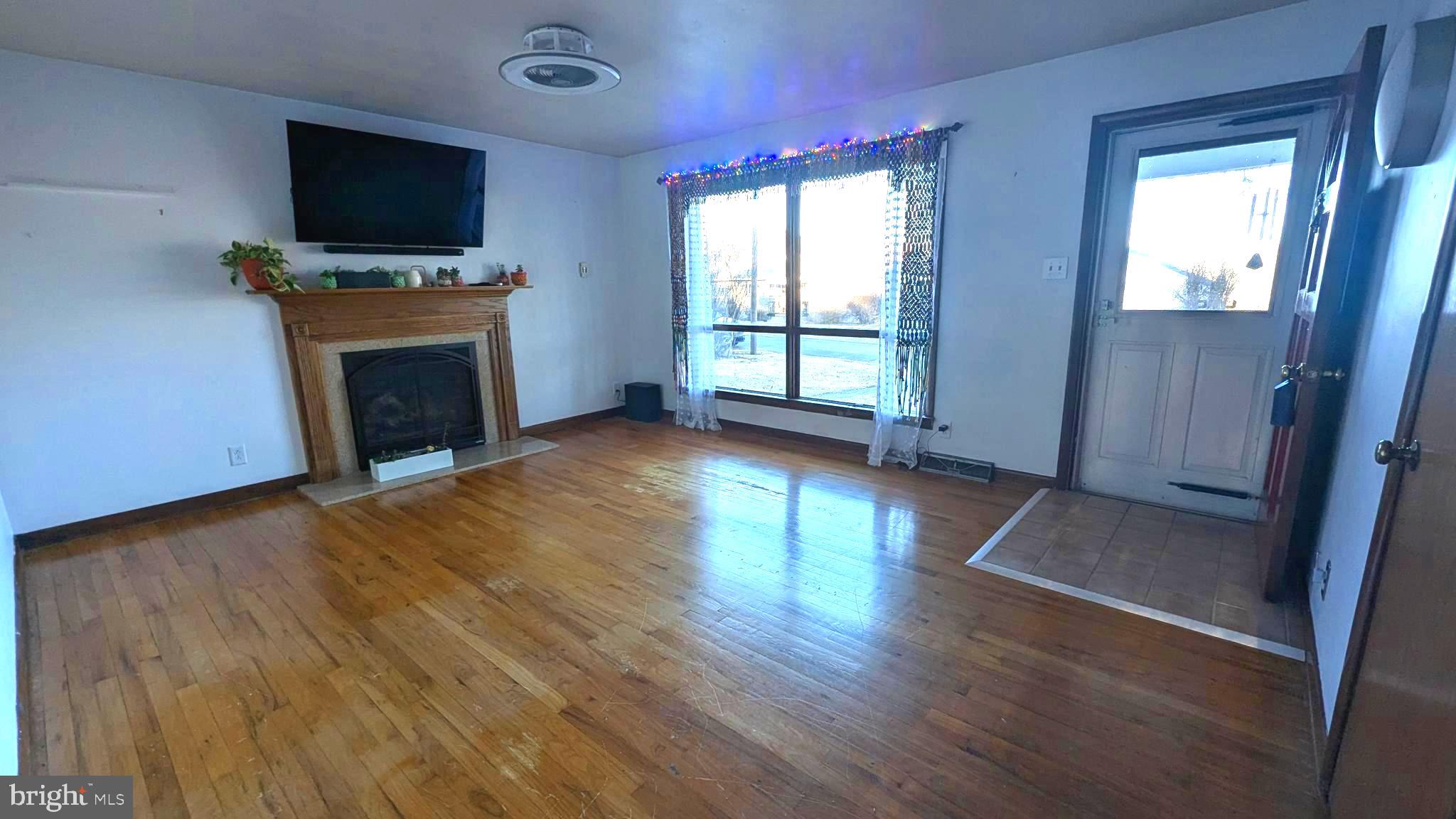 429 Simpson Street Bellefonte, PA 16823 - Photo 17 of 27 wooden floor fireplace and windows in an empty room