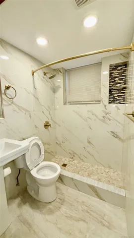 a bathroom with a toilet and a shower
