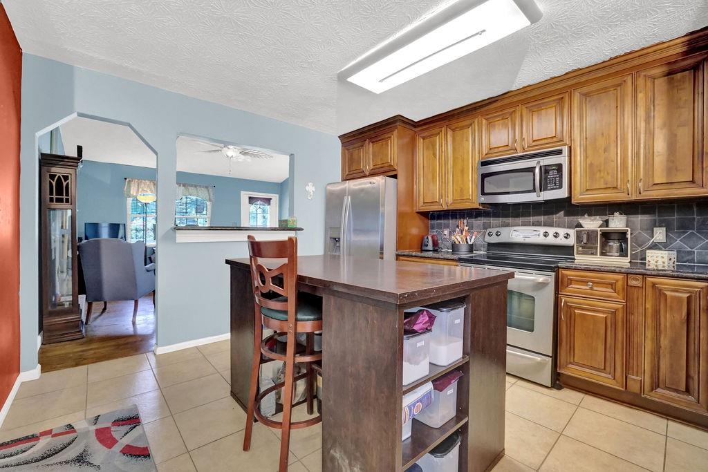 1555 Rock Springs Road Buford, GA 30519 - Photo 12 of 27 a kitchen with stainless steel appliances granite countertop wooden cabinets a refrigerator and a stove top oven