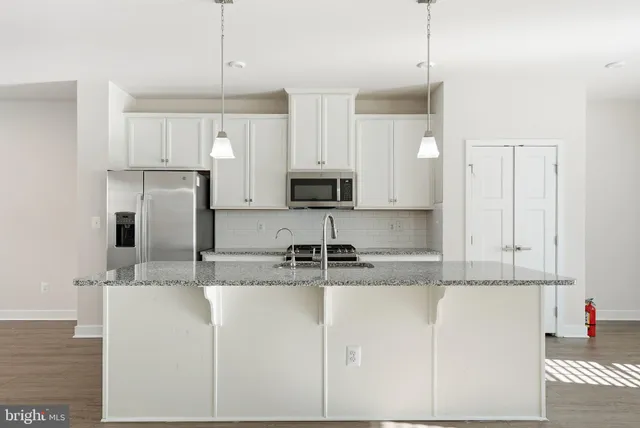 a kitchen with kitchen island a counter top space cabinets and stainless steel appliances