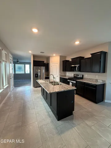 a large kitchen with stainless steel appliances and a sink