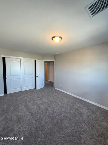 an empty room with closet and mirror