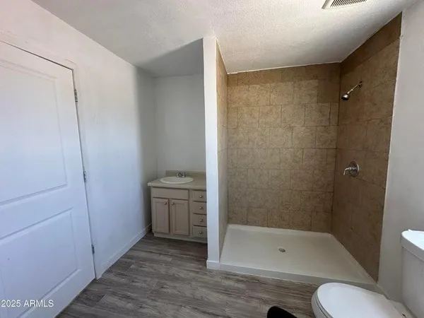 a bathroom with a granite countertop bathtub shower sink mirror and toilet