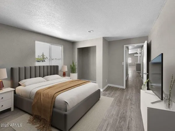 a bedroom with a bed and a flat tv screen on dresser