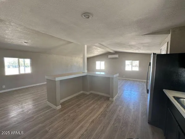 a view of empty room with wooden floor and window