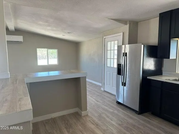 a kitchen with stainless steel appliances a refrigerator and wooden floor