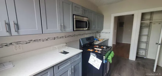 a kitchen with a sink stove and wooden floor