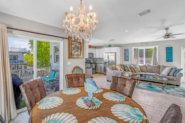 a dining room with furniture a large window and a chandelier