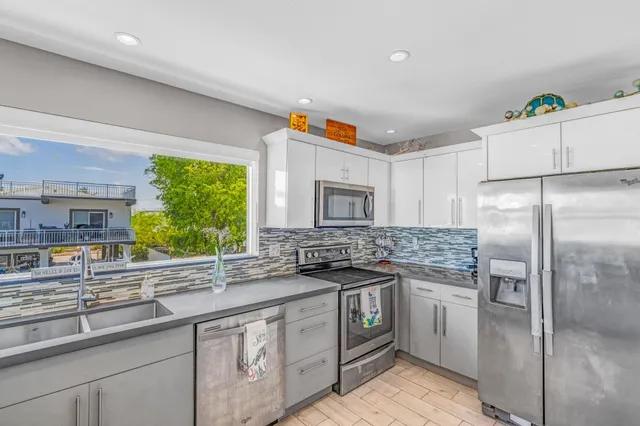 a kitchen with stainless steel appliances a sink stove and refrigerator