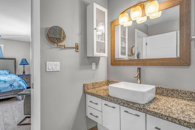 a bathroom with a granite countertop sink and a mirror