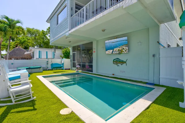 a view of a backyard with swimming pool