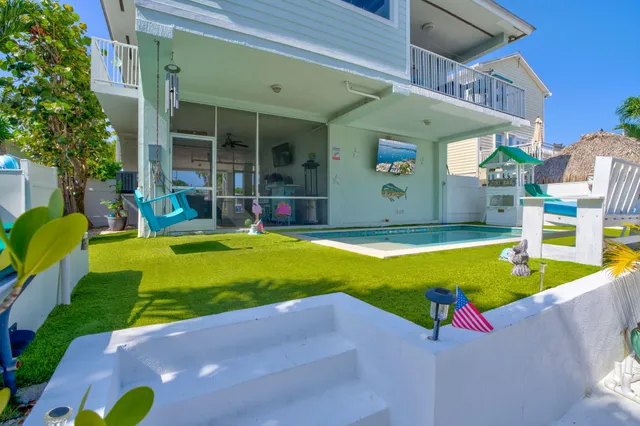 a view of a backyard with table and chairs under an umbrella